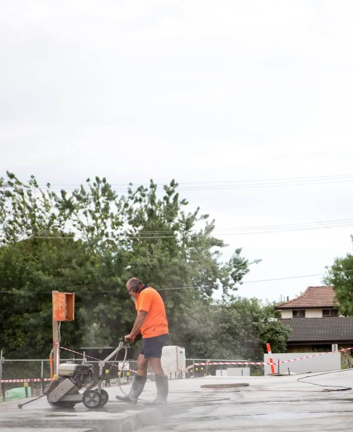 Buliding site with worker using a concrete cutter